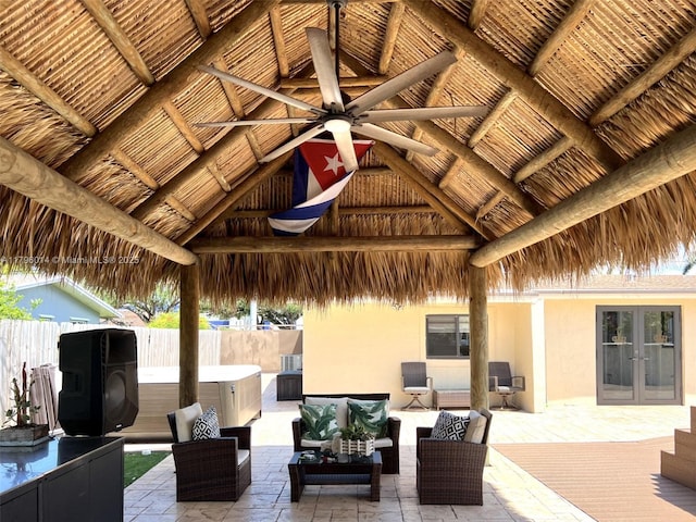 view of patio with a gazebo, a hot tub, french doors, a ceiling fan, and fence private yard