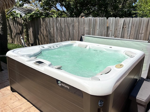 exterior space with a hot tub and fence