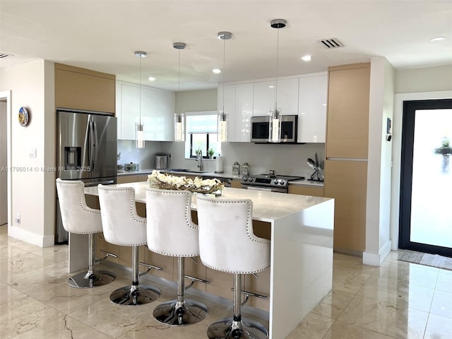 kitchen featuring stainless steel appliances, a breakfast bar, modern cabinets, and a center island