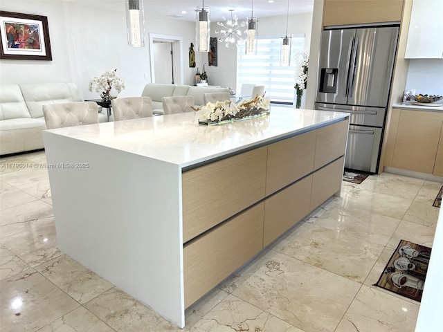 kitchen featuring stainless steel refrigerator with ice dispenser, open floor plan, and marble finish floor