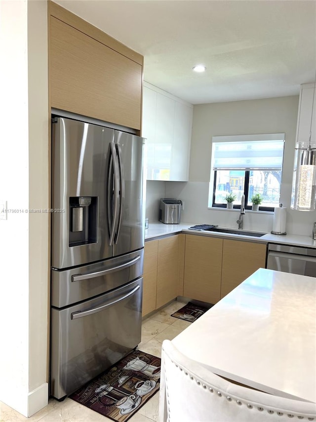 kitchen with a sink, appliances with stainless steel finishes, and light countertops