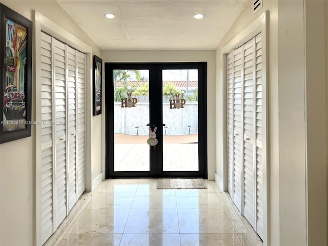 doorway to outside featuring recessed lighting, baseboards, visible vents, and french doors