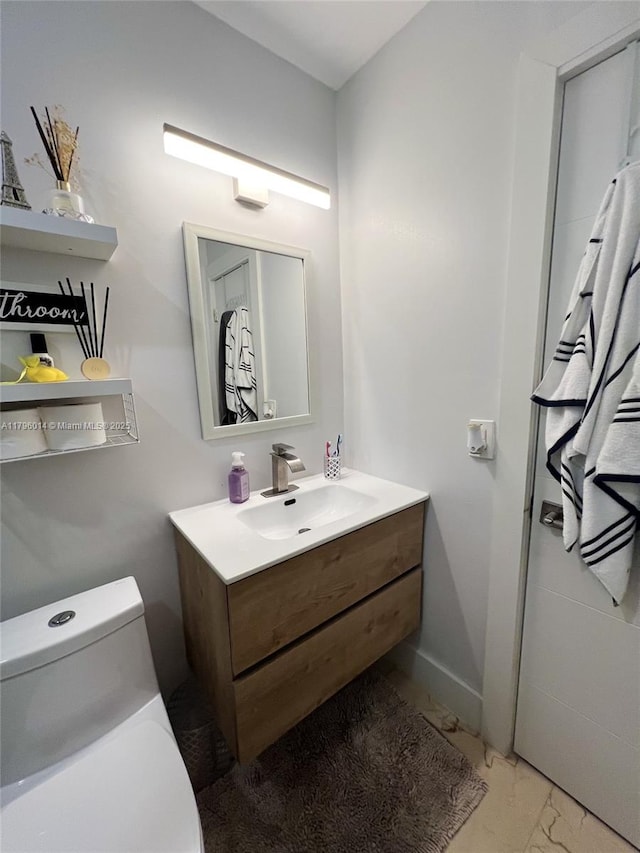 bathroom featuring vanity, marble finish floor, and toilet