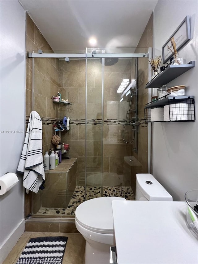 full bathroom featuring tile patterned floors, a shower stall, and toilet