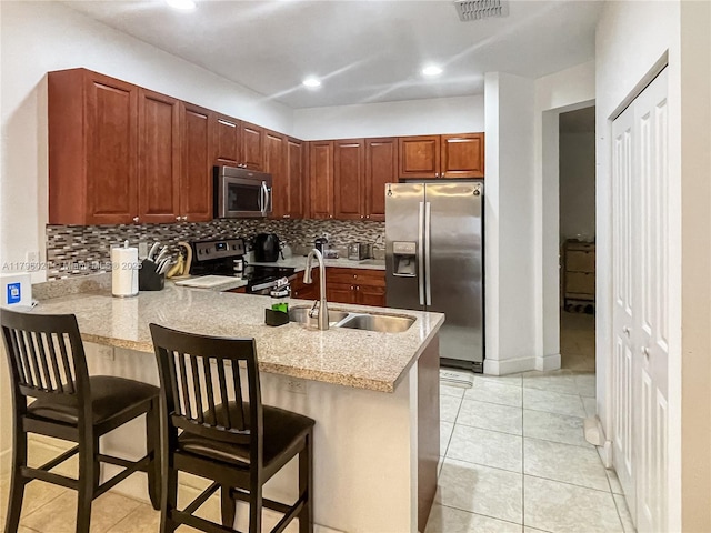 kitchen featuring decorative backsplash, visible vents, a sink, a peninsula, and stainless steel appliances