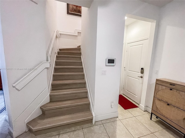 staircase with tile patterned floors and baseboards