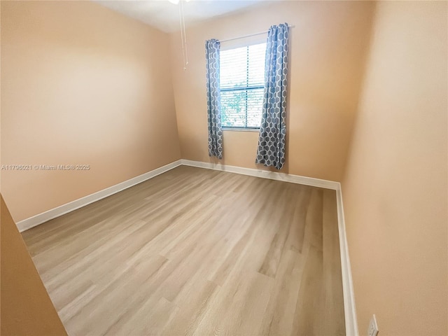 empty room with baseboards and wood finished floors