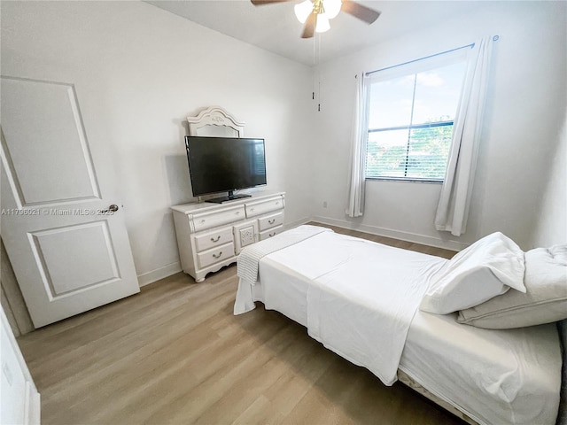 bedroom with baseboards, a ceiling fan, and light wood-style flooring