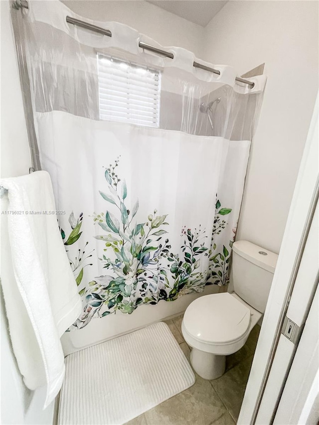full bathroom featuring tile patterned floors, toilet, and shower / tub combo