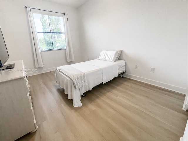 bedroom with light wood-style floors and baseboards