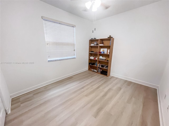 spare room with baseboards, light wood-style flooring, and ceiling fan
