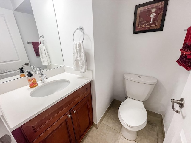 bathroom featuring vanity, tile patterned floors, baseboards, and toilet