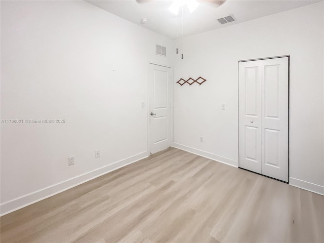 unfurnished bedroom featuring baseboards, light wood-style flooring, and visible vents