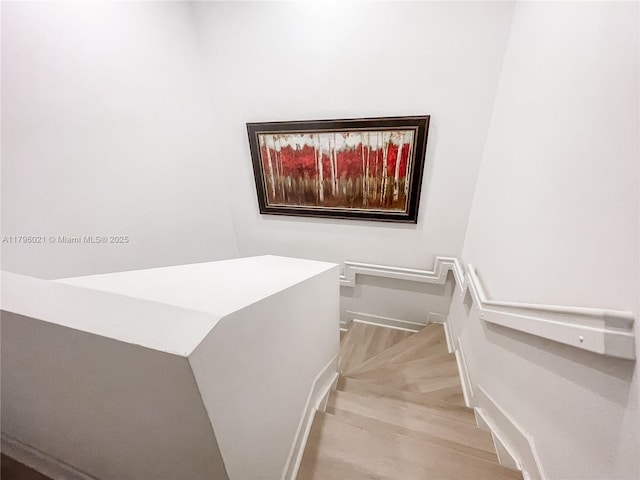 stairway featuring baseboards and wood finished floors