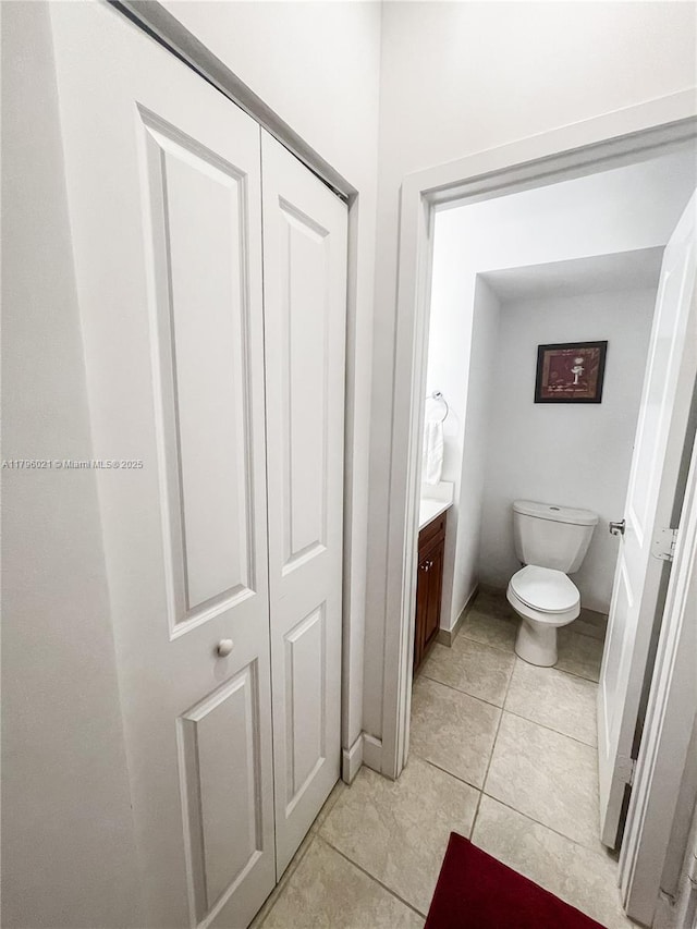 bathroom with toilet, tile patterned flooring, and vanity