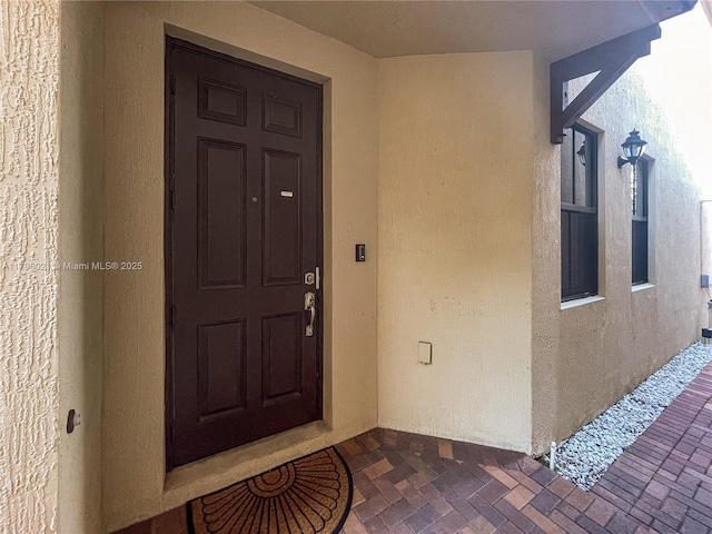 doorway to property featuring stucco siding