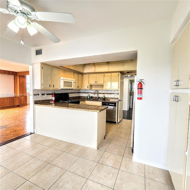 kitchen featuring visible vents, tasteful backsplash, light tile patterned floors, white microwave, and black range with electric cooktop