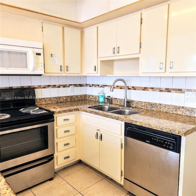 kitchen featuring backsplash, stainless steel appliances, light tile patterned flooring, and a sink