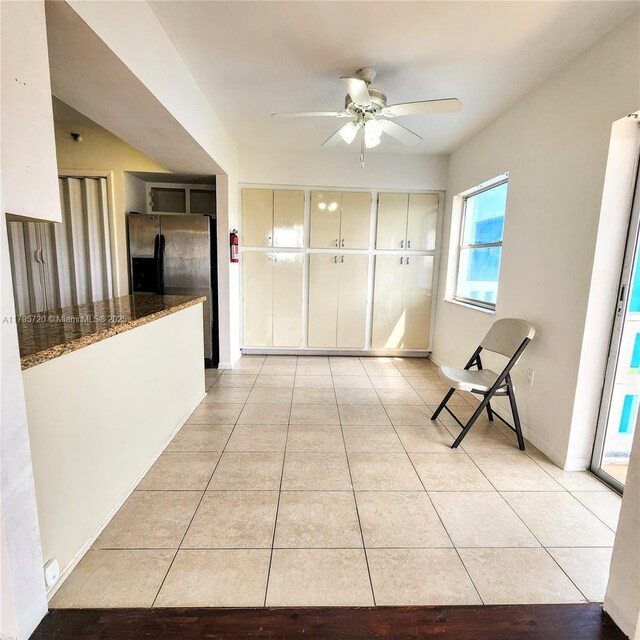 hall featuring baseboards and light tile patterned floors