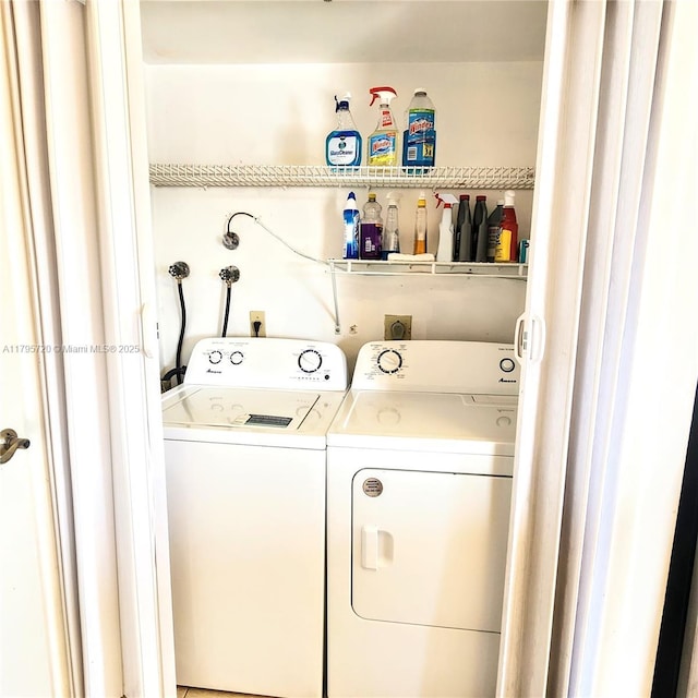 clothes washing area featuring separate washer and dryer and laundry area