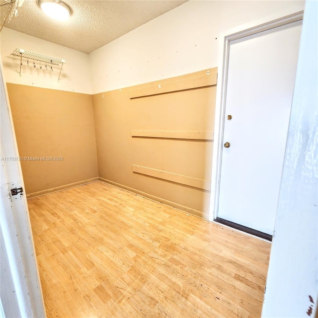unfurnished room featuring a textured ceiling and wood finished floors