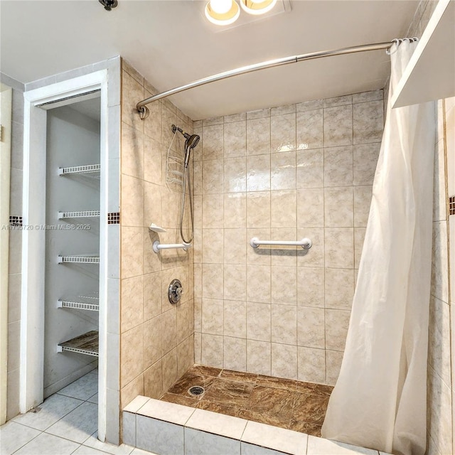 bathroom with tile patterned floors and a tile shower