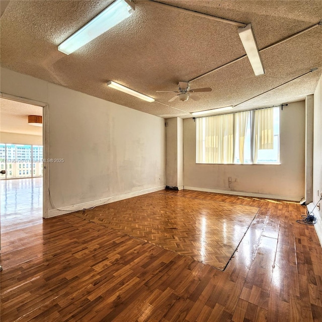 spare room featuring baseboards, a ceiling fan, a textured ceiling, and wood finished floors