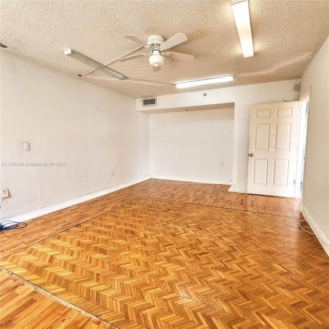 unfurnished room featuring visible vents, a textured ceiling, ceiling fan, and parquet flooring