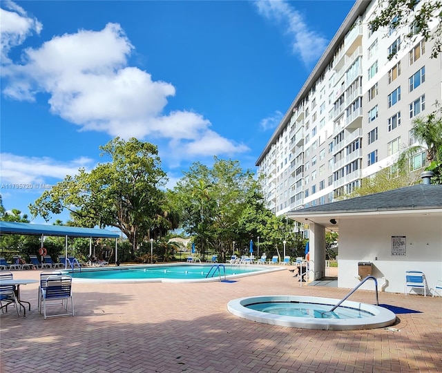 pool featuring a community hot tub and a patio area