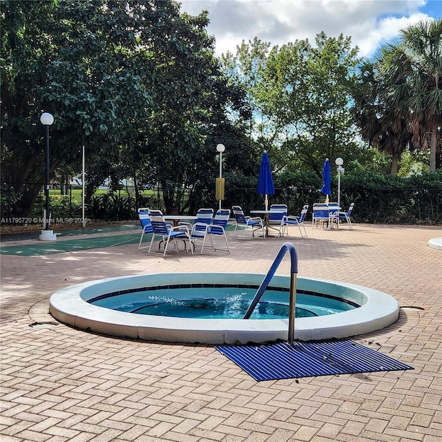 view of swimming pool featuring a hot tub