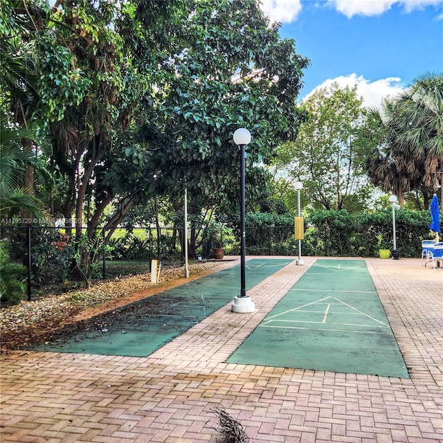 view of home's community featuring fence and shuffleboard