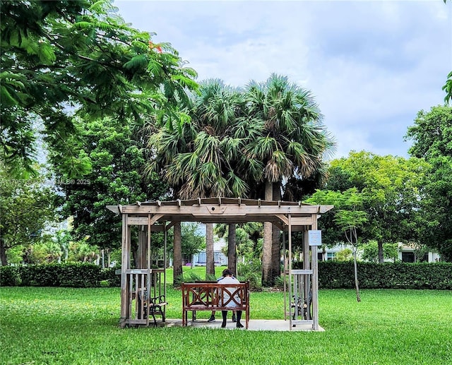 view of community featuring a pergola and a yard