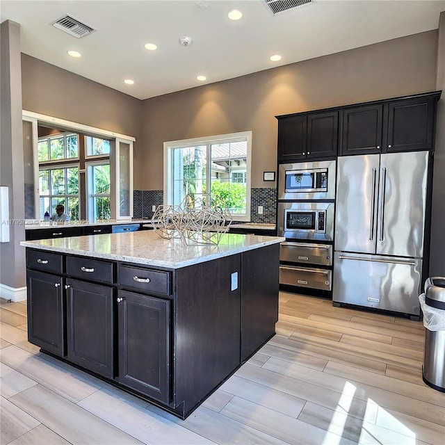 4001 Hillcrest Dr Unit 602-4, Hollywood, FL 33021 - kitchen featuring stainless steel appliances, backsplash, light stone countertops, dark cabinetry, and recessed lighting