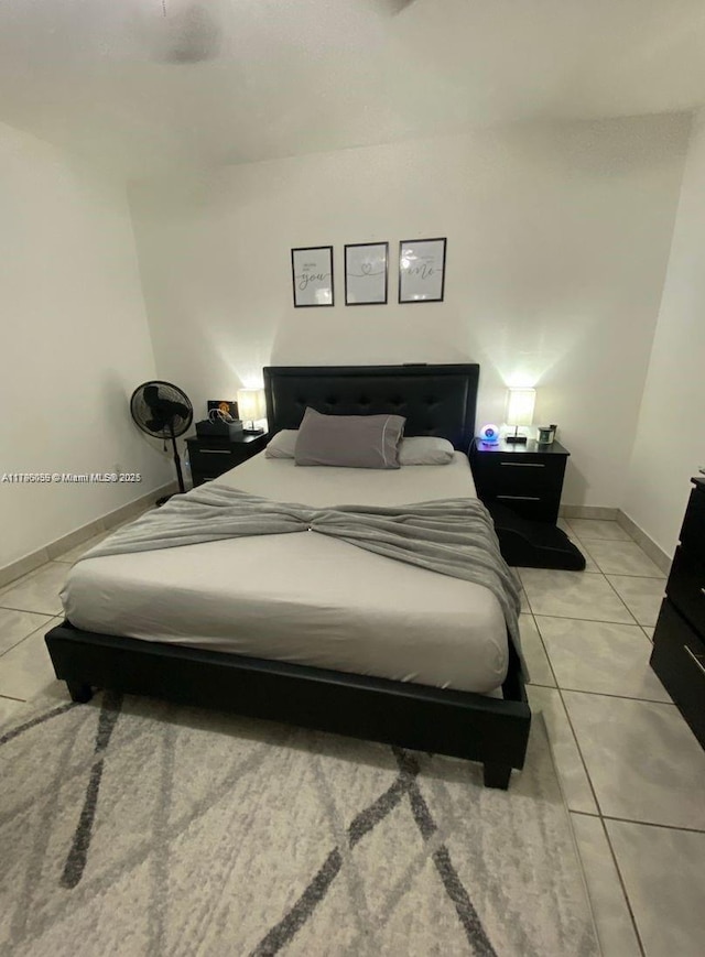 bedroom with baseboards and light tile patterned flooring