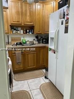 kitchen featuring light countertops, ceiling fan, white refrigerator with ice dispenser, and open shelves