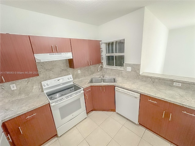 kitchen with white appliances, under cabinet range hood, a sink, and light countertops