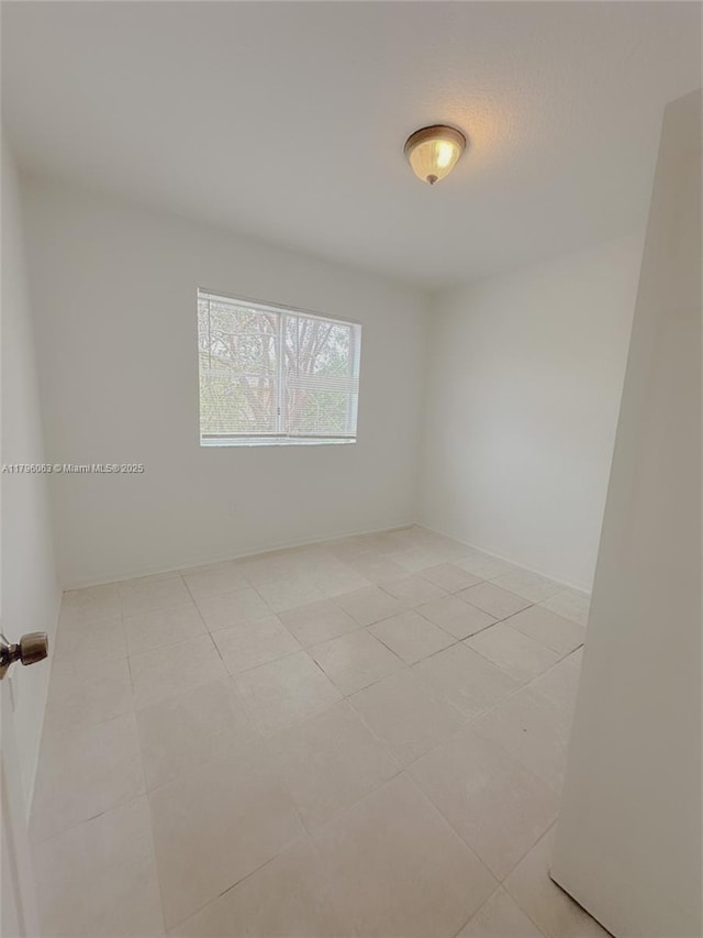 spare room featuring light tile patterned flooring