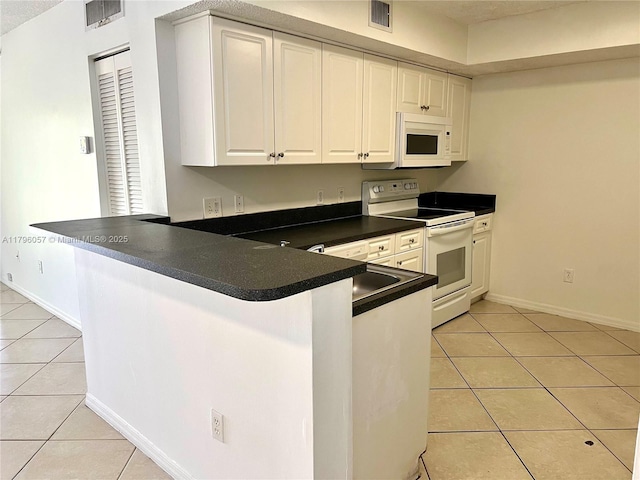 kitchen featuring visible vents, light tile patterned floors, and white appliances