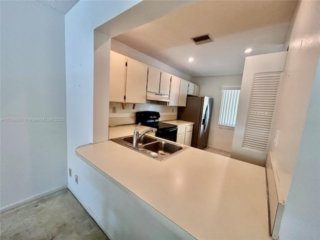 kitchen featuring a sink, stainless steel fridge with ice dispenser, under cabinet range hood, visible vents, and black range with electric stovetop