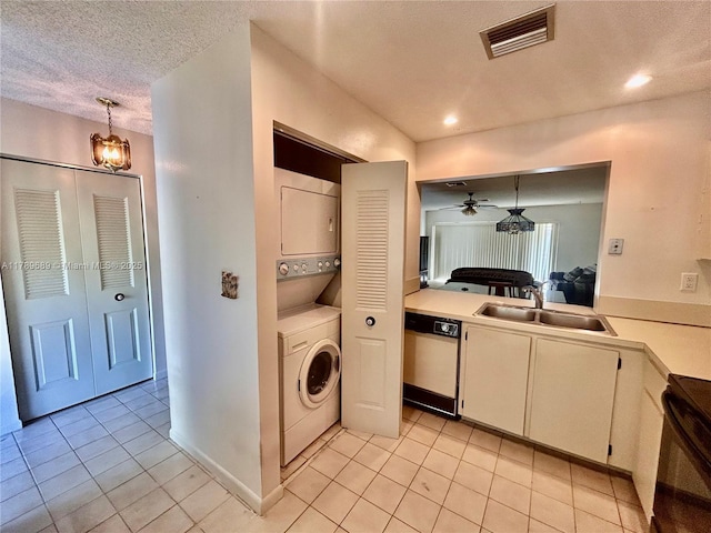 kitchen featuring visible vents, stacked washer and clothes dryer, light tile patterned floors, and dishwasher