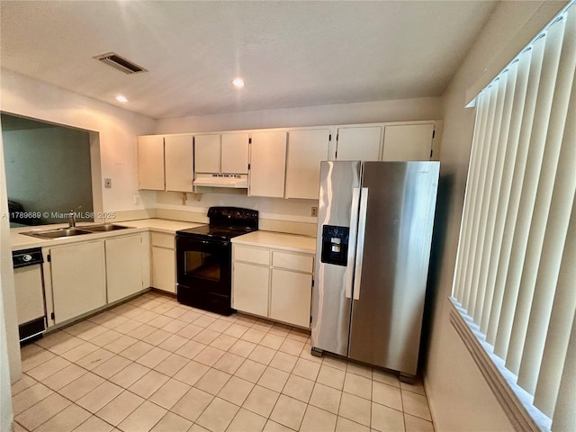 kitchen featuring stainless steel fridge, light countertops, under cabinet range hood, black range with electric stovetop, and a sink
