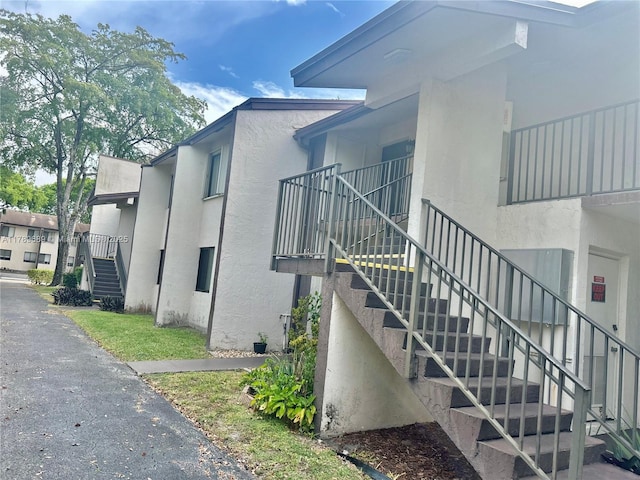 view of home's exterior with stairs and stucco siding