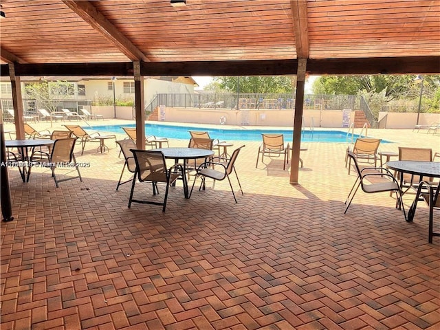 community pool with fence and outdoor dining area