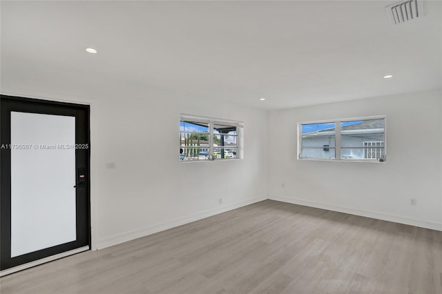 empty room featuring recessed lighting, baseboards, visible vents, and wood finished floors