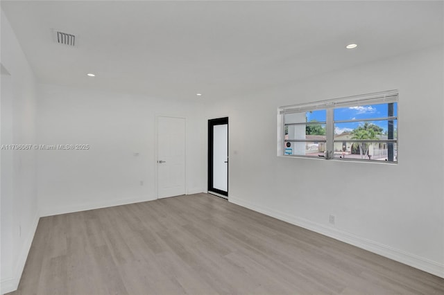 empty room featuring visible vents, recessed lighting, baseboards, and wood finished floors