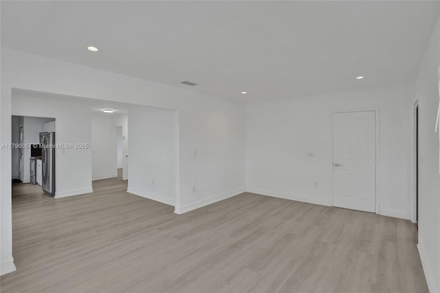 spare room featuring recessed lighting, light wood-style flooring, baseboards, and visible vents