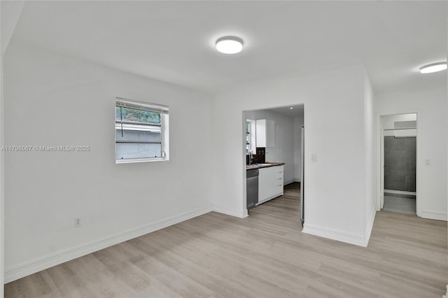 unfurnished living room with baseboards and light wood-style flooring