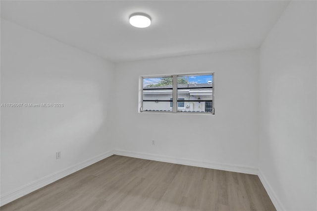 unfurnished room featuring baseboards and wood finished floors