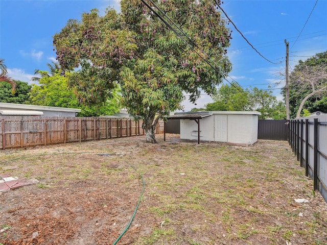 view of yard with a fenced backyard, a storage unit, and an outdoor structure