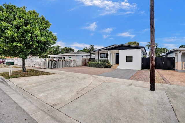 view of front of property featuring driveway, a fenced front yard, and stucco siding